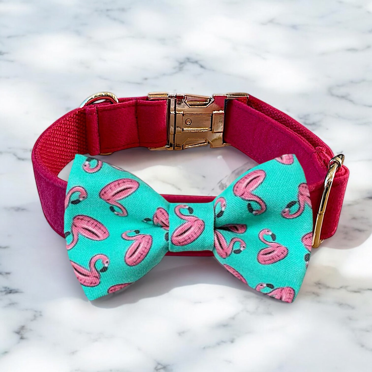 Dog collar with a turquoise bow tie featuring pink flamingo patterns on a marble background