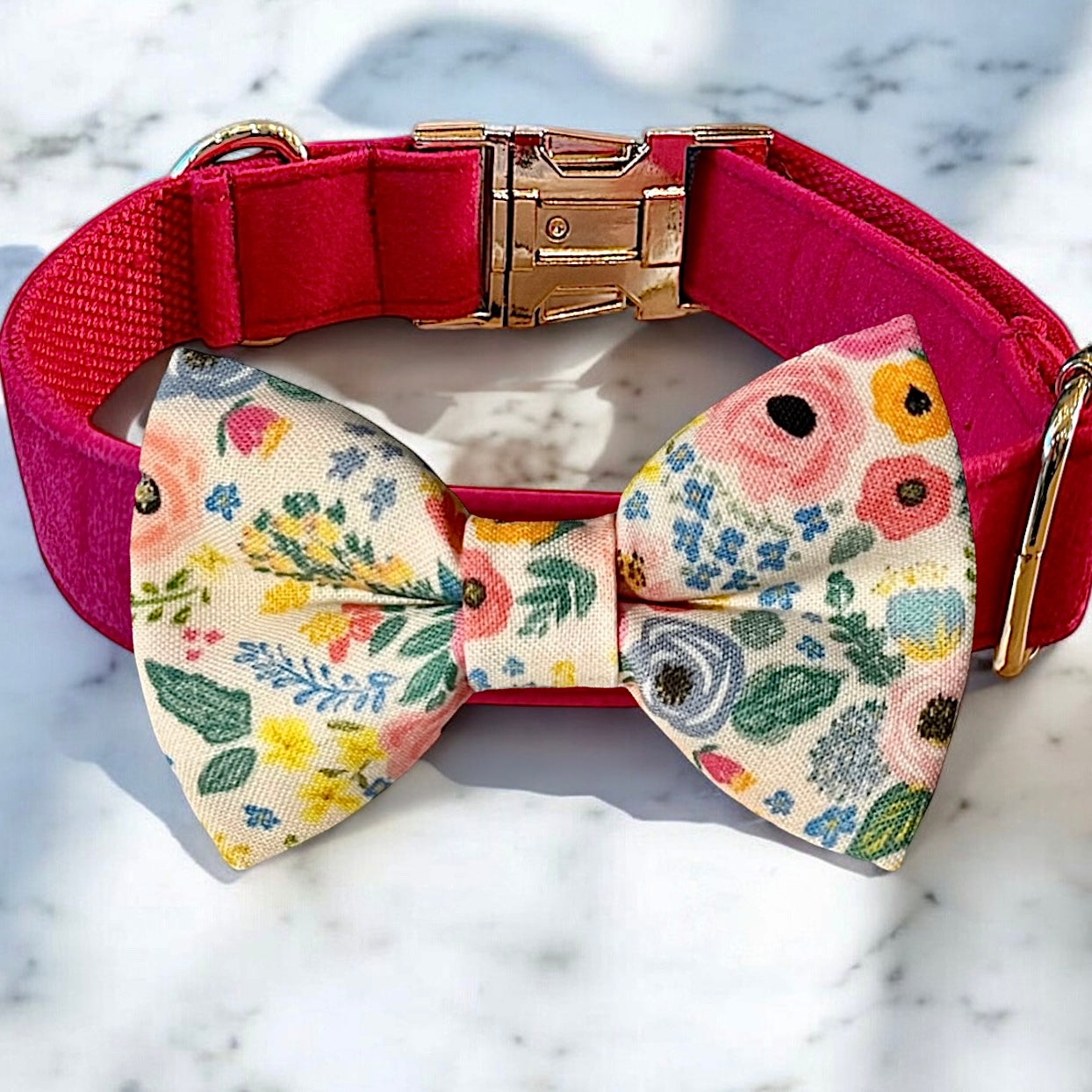 Dog collar with a floral bow tie on a marble surface