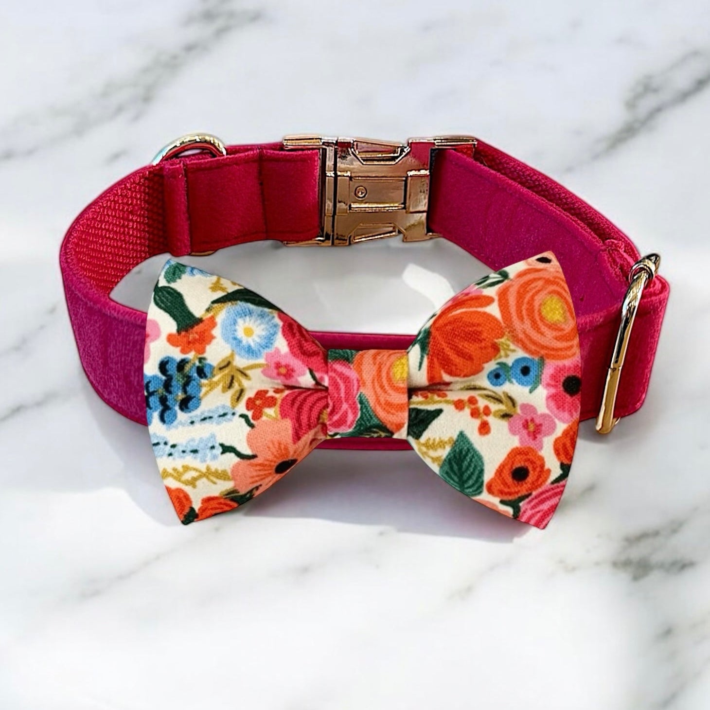 Dog collar with a colorful floral bow tie on a marble background