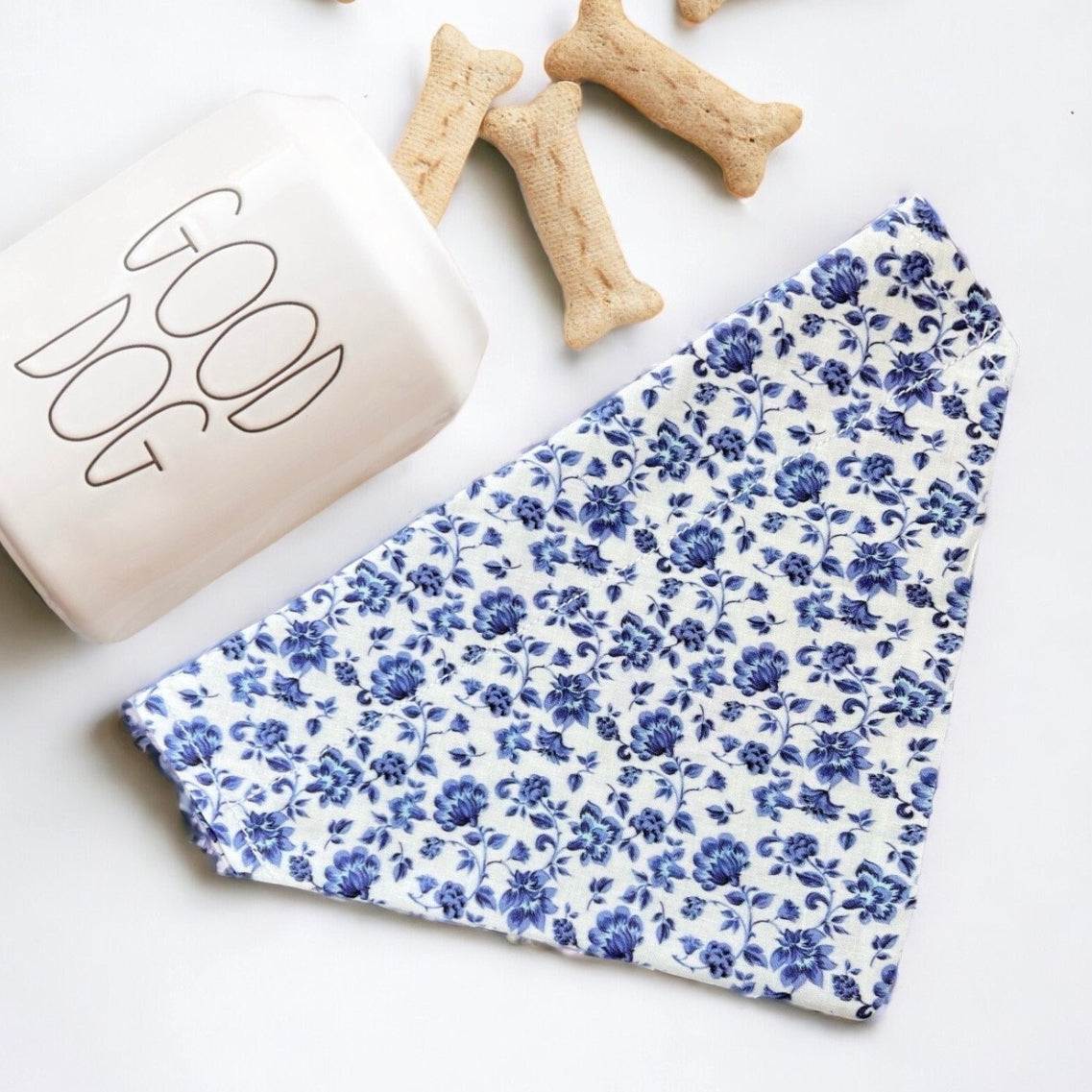 a dog bandana next to a bone bone and a dog treat