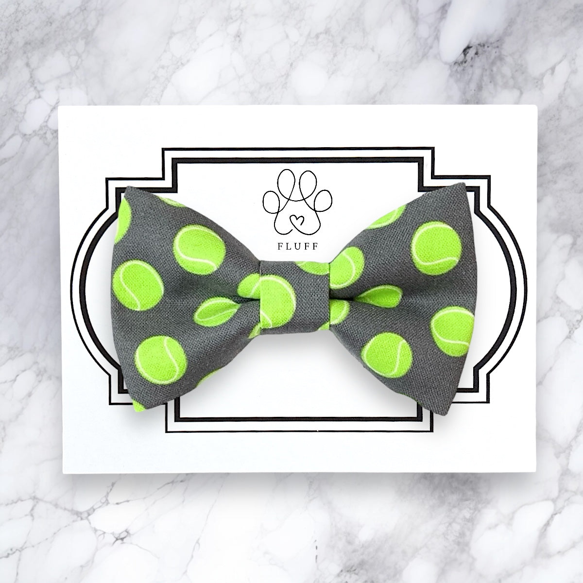 a gray and green bow tie with tennis balls on it