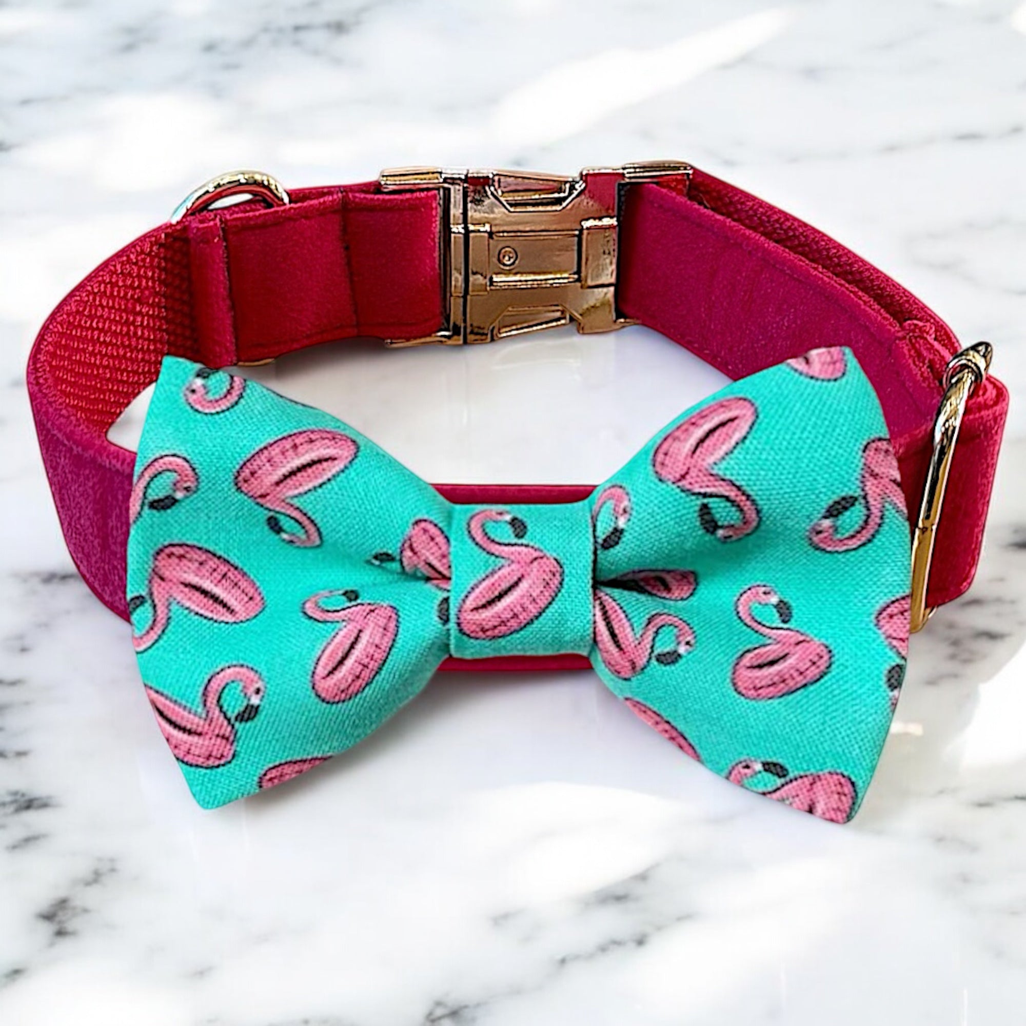 Dog collar with a turquoise bow tie featuring pink flamingo patterns on a marble background