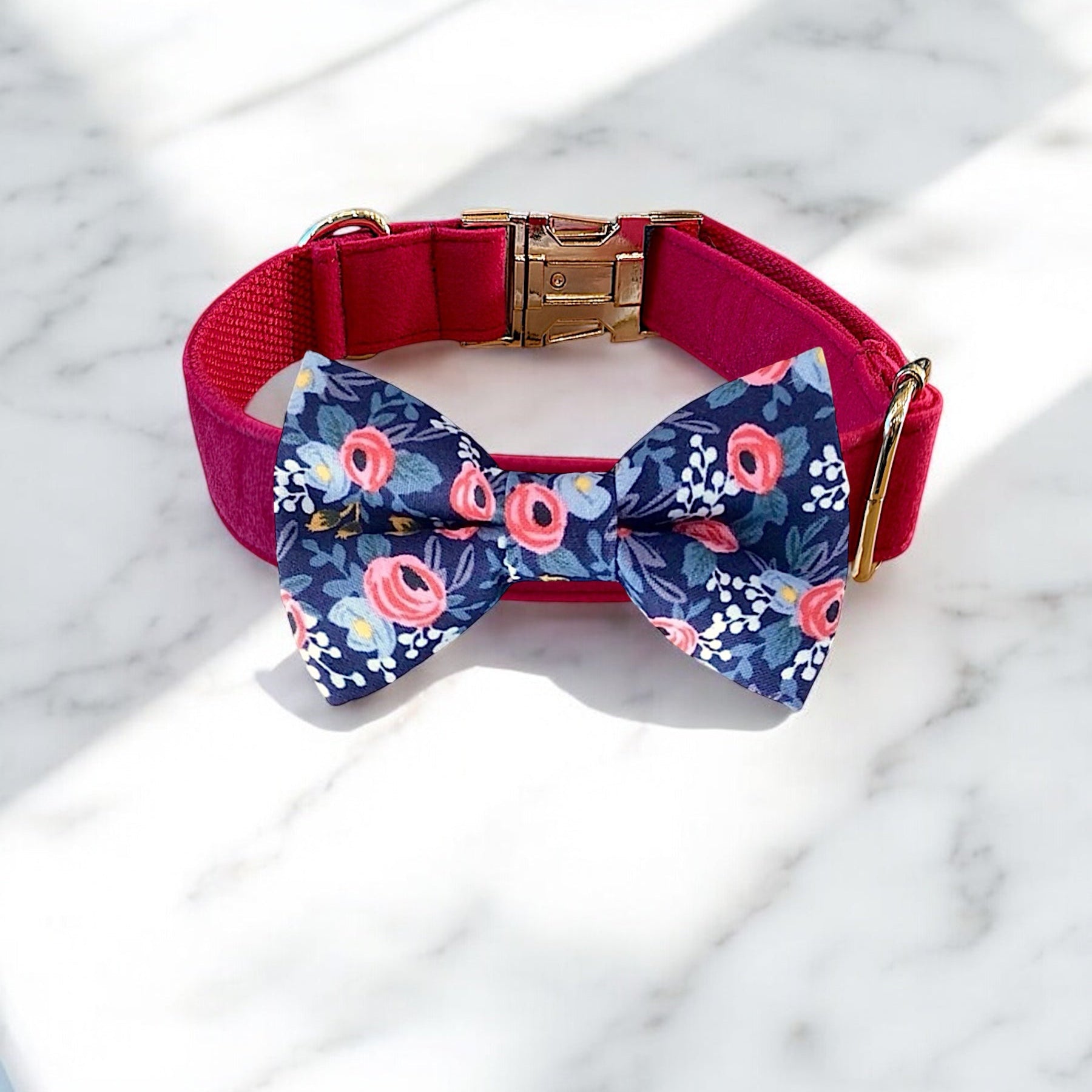 Dog collar with a floral bow tie on a marble surface
