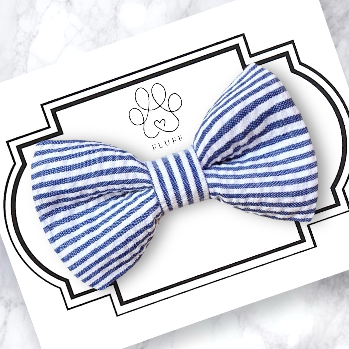 Blue and white striped dog bow on a branded card with a white background