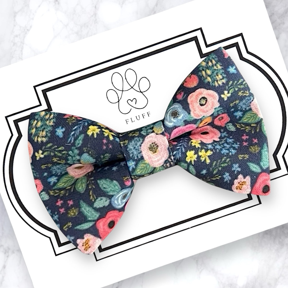 Wonderland garden navy dog bow tie on a branded card with 'FLUFF' logo.