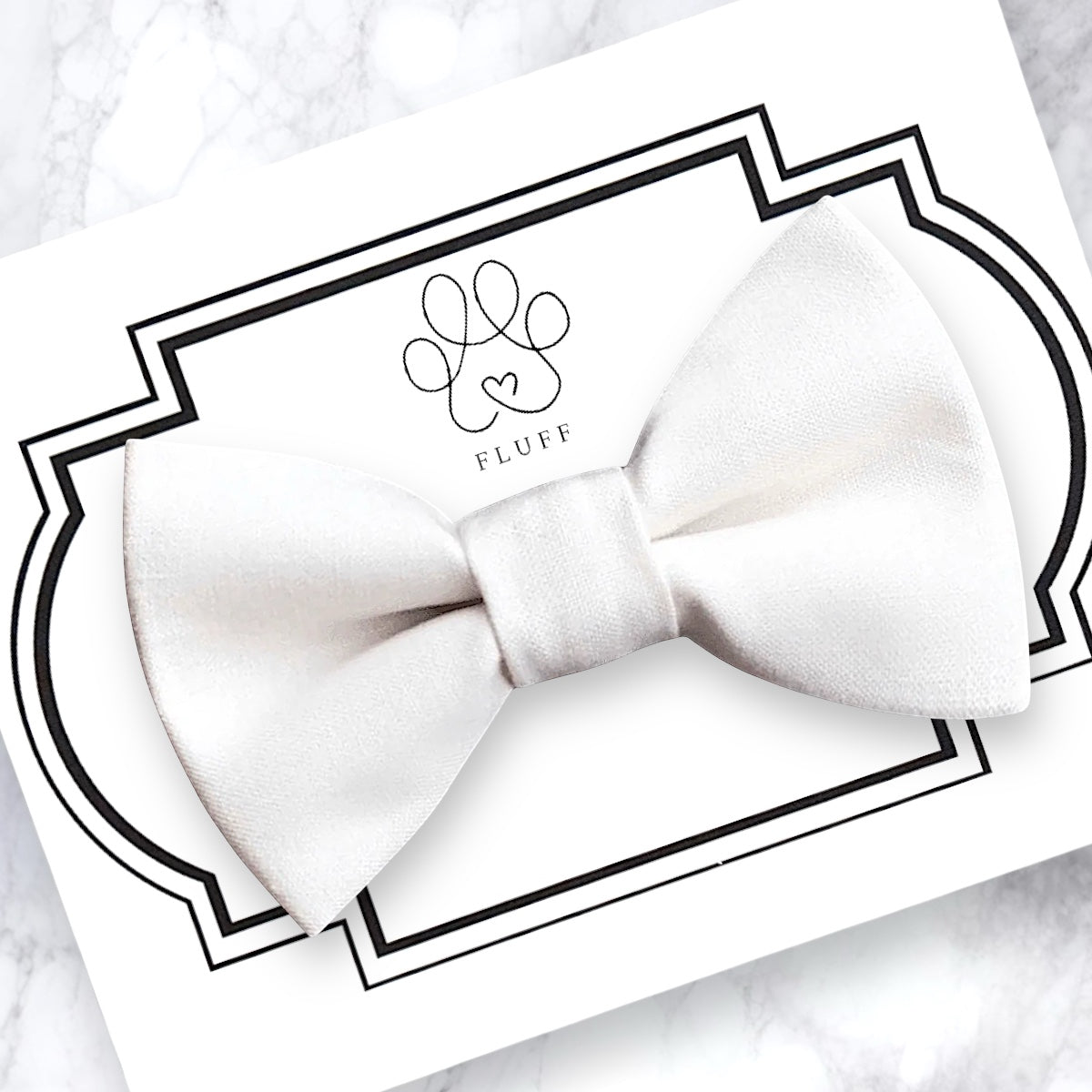 White pet bow tie on a branded card with 'Fluff' logo