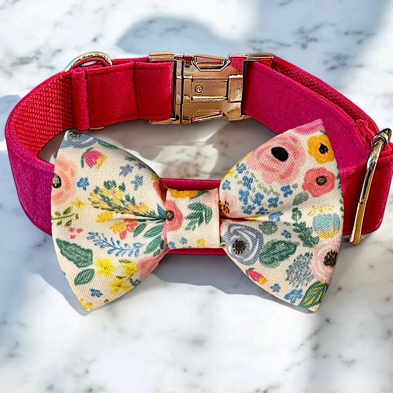 Dog collar with a floral bow tie on a marble surface