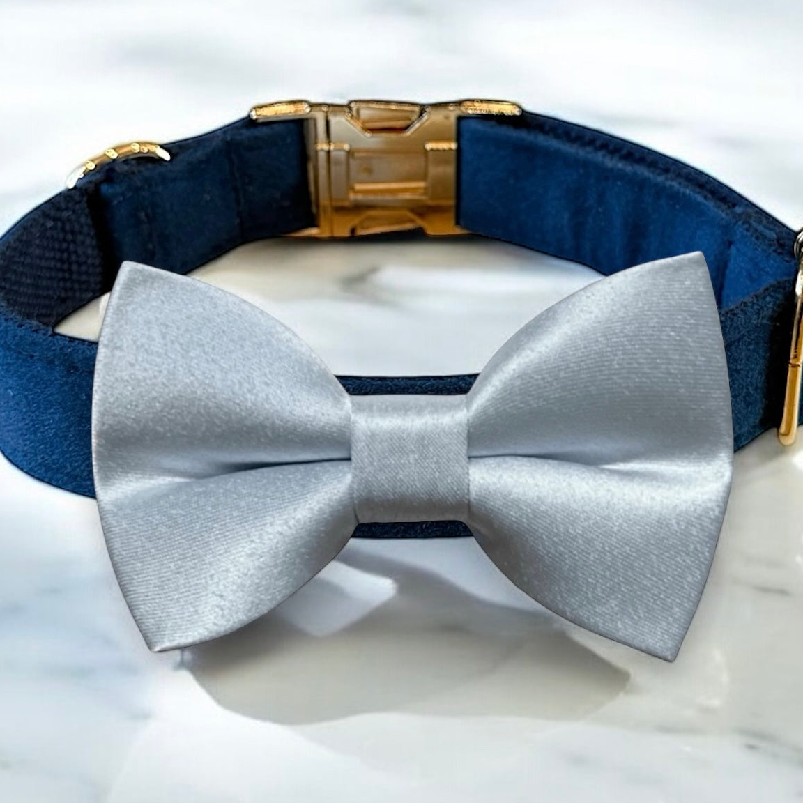 A blue bow tie is displayed on a blue collar, which is part of a matching collar and leash set.