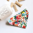 a dog bone bone next to a colorful floral napkin