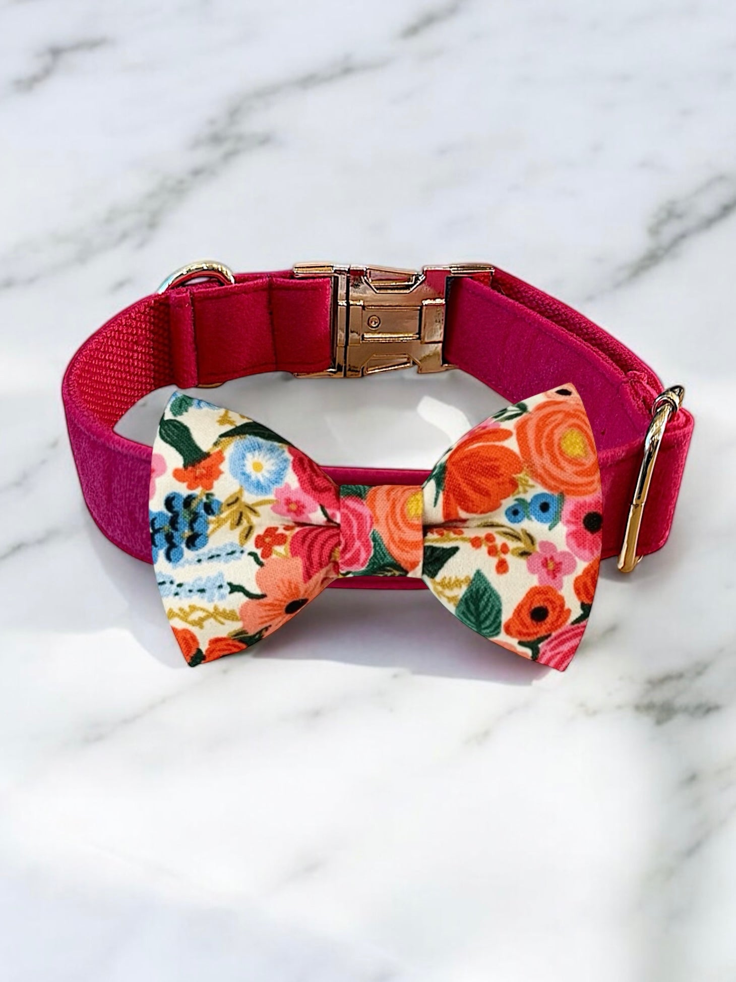 Dog collar with a colorful floral bow tie on a marble background