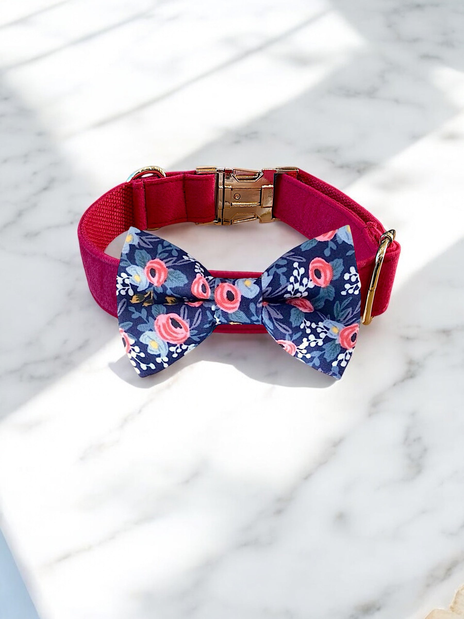 Dog collar with a floral bow tie on a marble surface