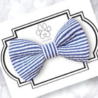 Blue and white striped dog bow on a branded card with a white background