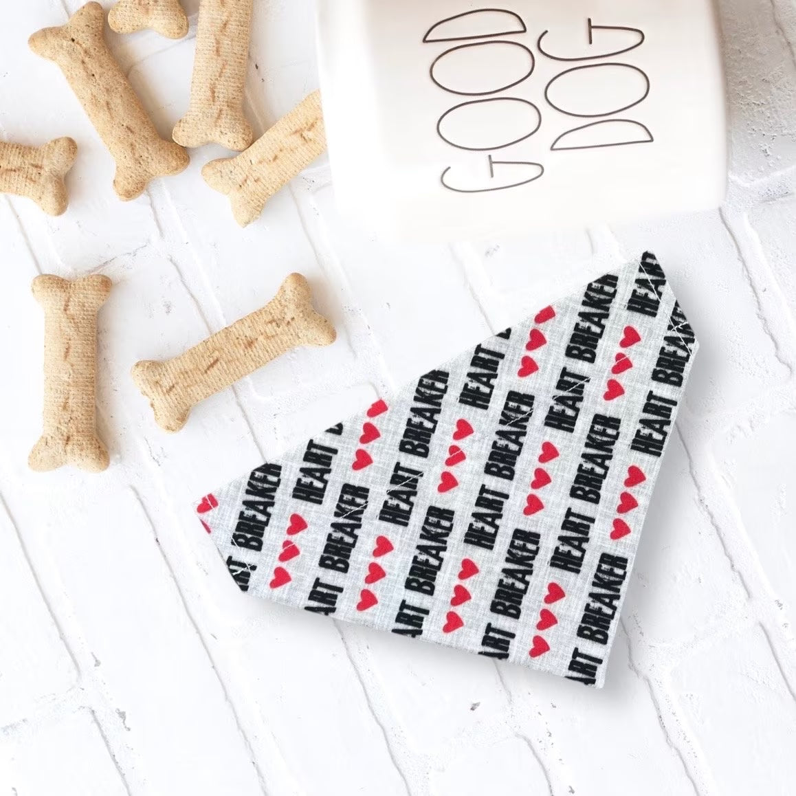 a dog bone next to a bowl of dog treats