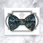 Patterned bow tie on a white card with 'FLUFF' branding on a marble background