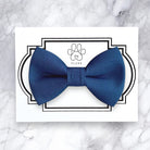 Steel blue bow tie on a white card with 'FLUFF' branding on a marble background