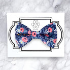 Floral patterned dog bow tie on a white card with 'FLUFF' branding on a marble background