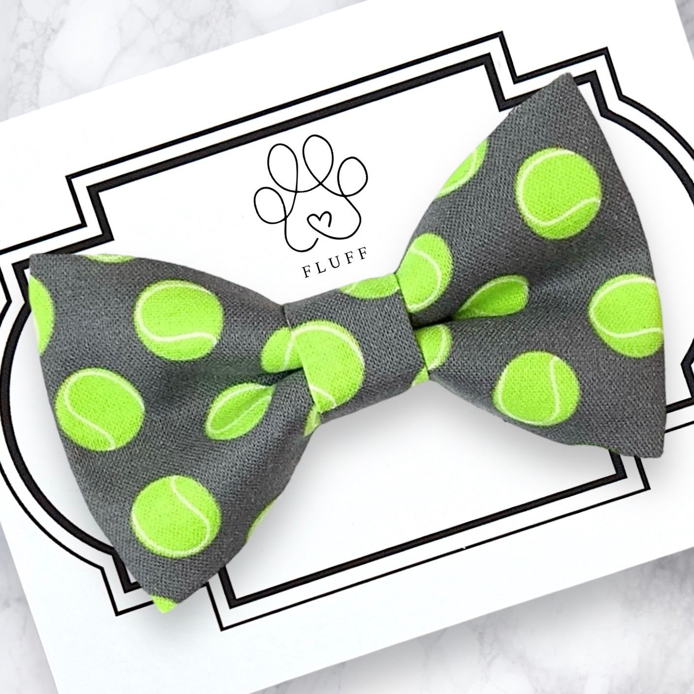 a bow tie with a green tennis ball on it